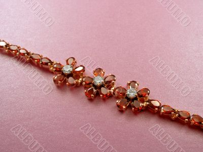 Jewelry bracelet with garnets on pink background
