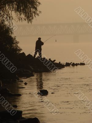 Silhuette of alone fisher near sunset river