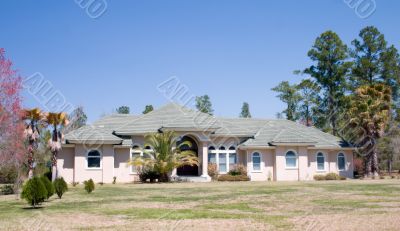 upscale stucco home with gray tile roof