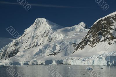 Mountains &amp; glaciers reflected in calm ocean