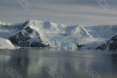 Mountains &amp; glaciers reflected in calm ocean