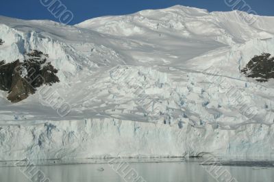 Mountains &amp; glaciers reflected in calm ocean