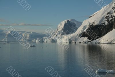 Mountains &amp; glaciers reflected in calm ocean