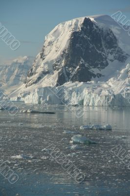 Mountains &amp; glaciers reflected in calm ocean