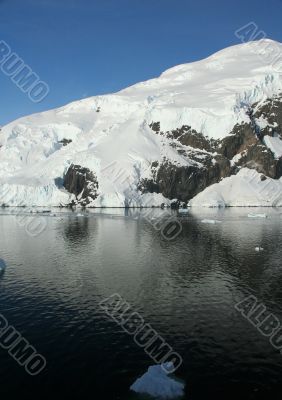 Mountains &amp; glaciers reflected in calm ocean