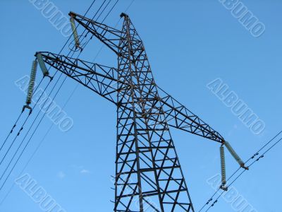 Powerline tower seen from below against blue sky