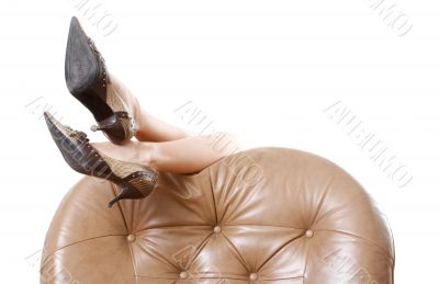 Woman`s beautiful long legs laying on the armchair