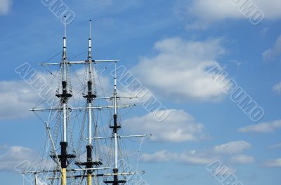 masts of frigate over blue sky with space for text