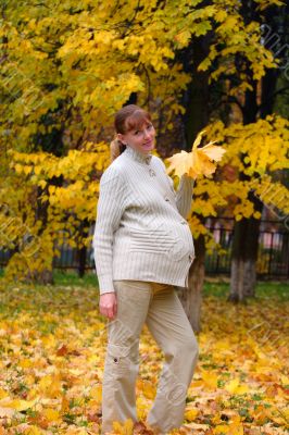 Pregnant woman in autumn park hold maple leaf #4