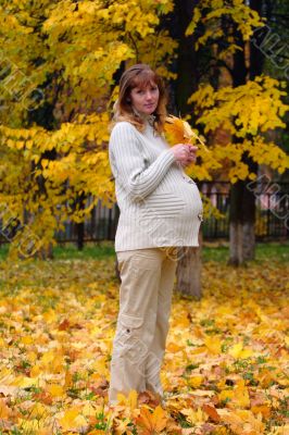Pregnant woman in autumn park hold maple leaf #5