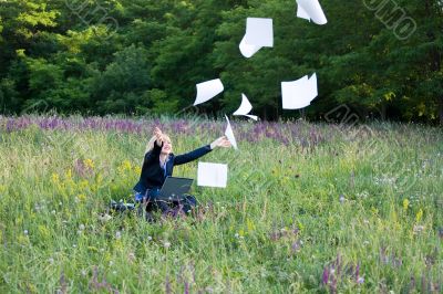 Businesswoman on nature with laptop catch documents #2