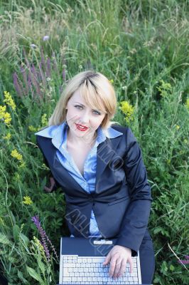 Businesswoman on grass with laptop 2