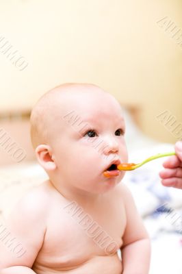 Baby eating by plastic spoon