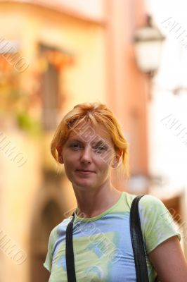 Pretty red-headed girl on street look at camera