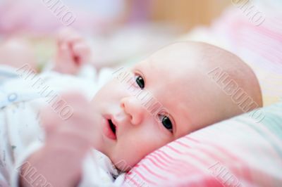 Baby lying on bed. Close up