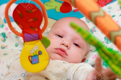 Baby playing with toys. Little boy touching the toy by finger.