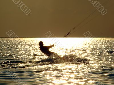 Silhouettes kitesurf on a gulf on a sunseet