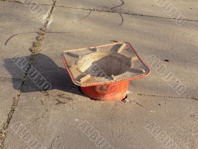 construction cone filling pothole in sidewalk