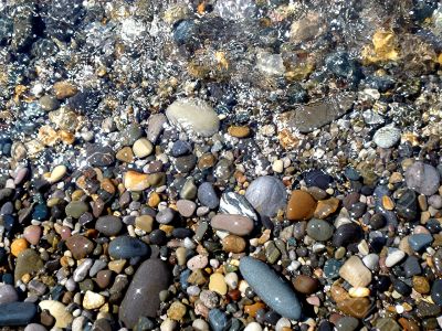 Wet brilliant pebble and sea wave