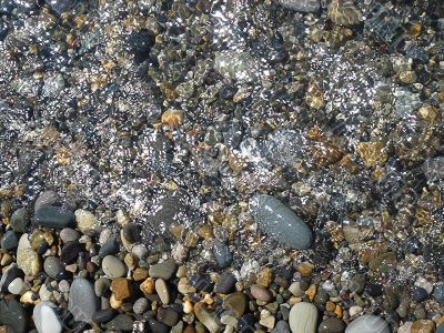 Wet brilliant pebble and sea wave