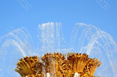 Golden fountain on blue sky
