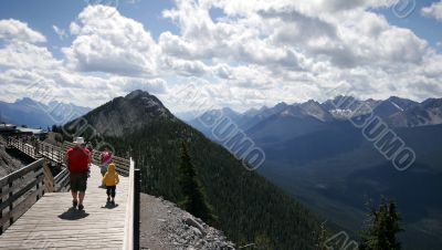 Family walks along a trail on Sulfer Mountain in Banff Family walks along a trail on Sulfer Mountain in Banff