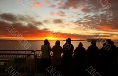 Cruise ship passengers taking pictures of sunset