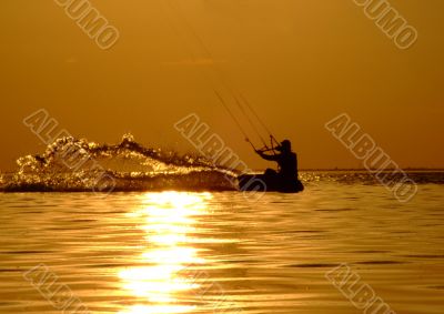 Silhouette of a kitesurf on a gulf on a sunset