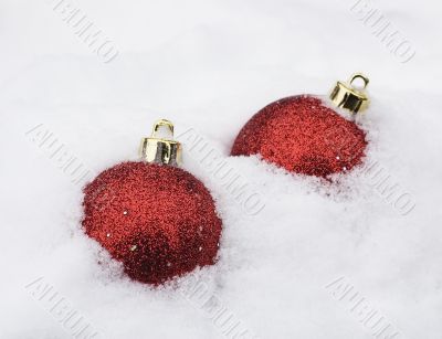 two christmas baubles in white snow