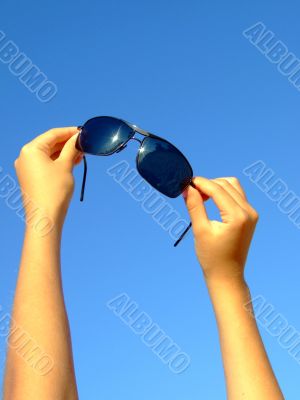 Female hands hold sunglasses