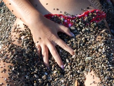 The sexual girl in a pebble on a beach