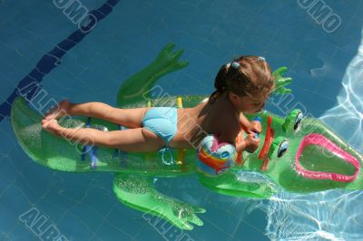 Girl swimming on crocodile