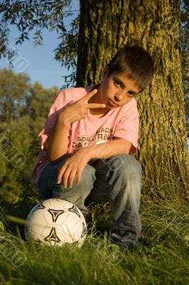 boy showing peacesign and holding soccer boy showing peacesign and holding soccer