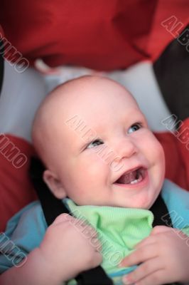 Baby sitting in stroller. First teeth