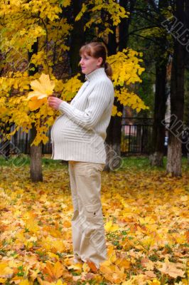 Pregnant woman in autumn park hold maple leaf #3
