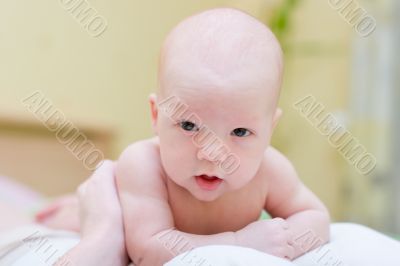 Baby resting on mother`s chest and look at camera