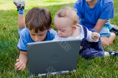 Three cute brothers study on computer