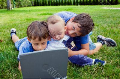 Three cute brothers study on computer