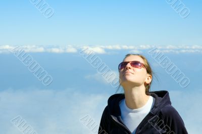 smiling girl looking in the blue cloudy sky with copyspace