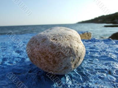 Greater pebble on a dark blue surface