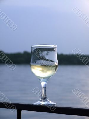 Glass of white wine on a background of the river Glass of white wine on a background of the river