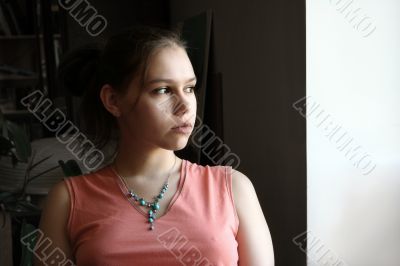 Unhappy teen by the window