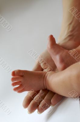 newborn`s feet on woman`s palm