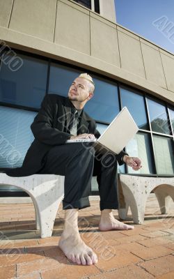 Barefoot Punk Businessman with his Laptop Computer