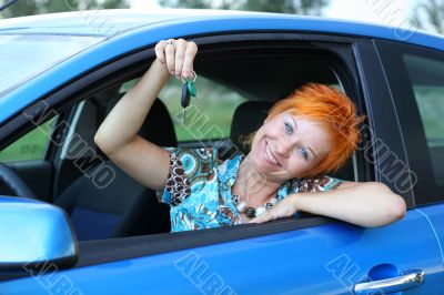 Young woman in a car with key