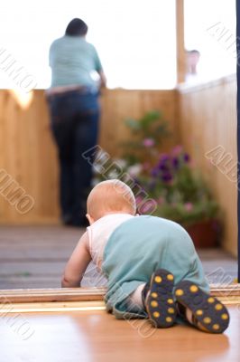 Little baby crawling to his father staying on terrace