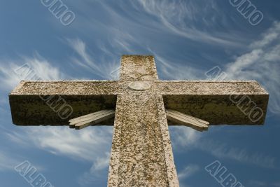 Weathered cross blue sky and wispy clouds