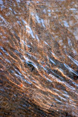 Transparent flowing water and sand