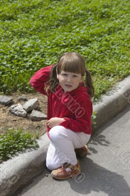 Little girl playing near city lawn