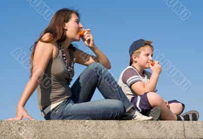 Mum and son eat peaches